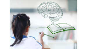 A girl with a ponytail is writing in a notebook. A green illustration of a brain connected to an open book is superimposed in front of her.