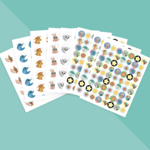 Six sheets of the Squiggle Squad Sticker Pack laid out in a fan on a teal surface.