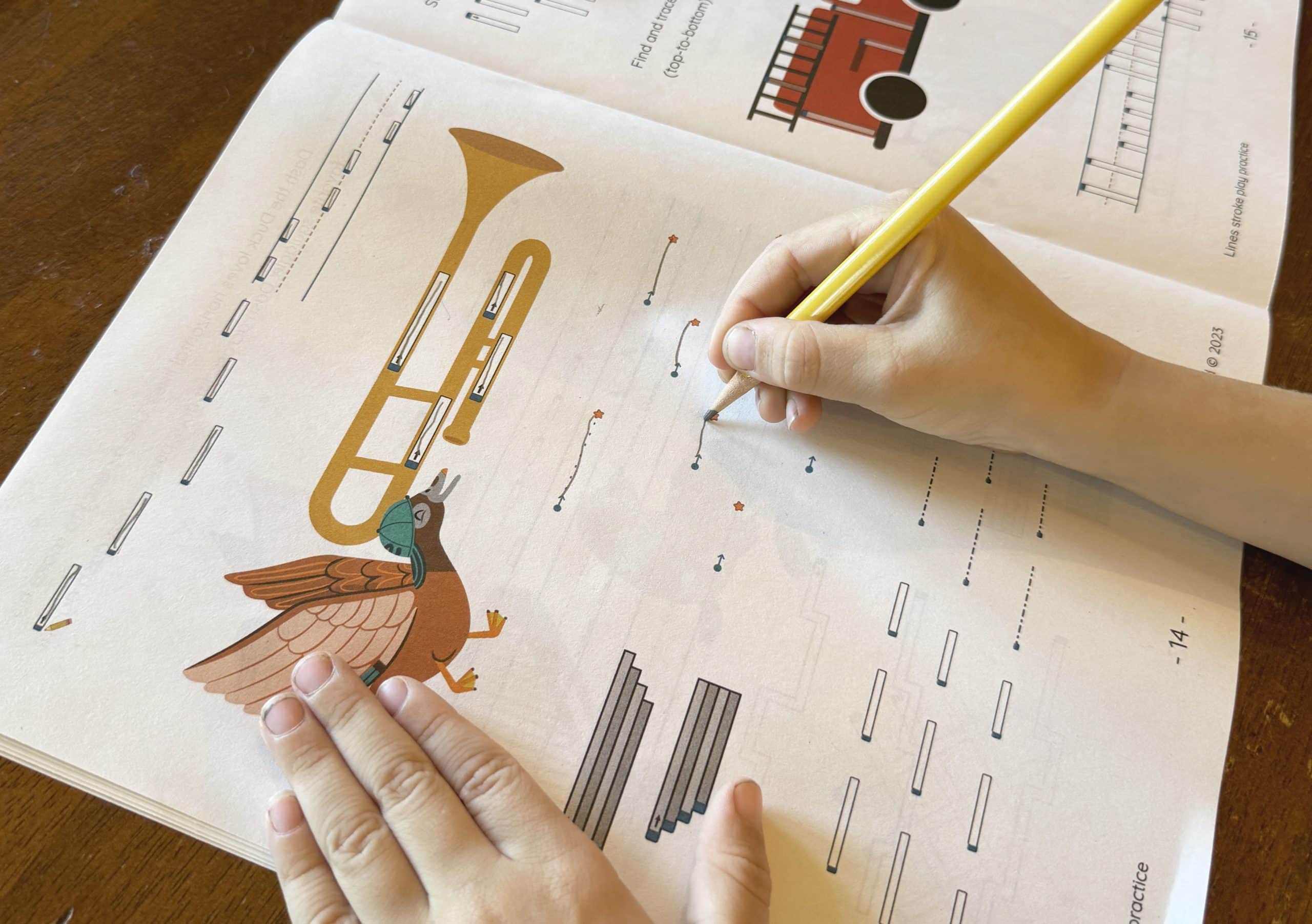 Child writing in a workbook with a pencil, practicing the letter "S" on lined paper featuring animal illustrations.